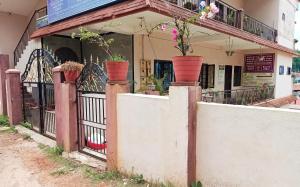 Coorg villas apartment stay في ماديكيري: منزل به نباتات الفخار على السياج