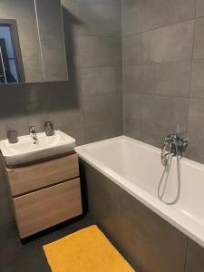 a bathroom with a white tub and a sink at Garden Apartman Radnica in Košice