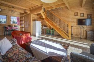 a living room with a staircase in a log cabin at Tajgołka in Murzasichle