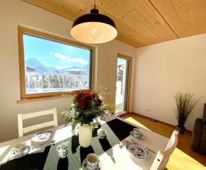 ein Esszimmer mit einem Tisch und einem großen Fenster in der Unterkunft Ferienwohnung Das LechSide in Pflach