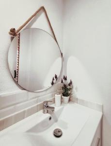 een witte badkamer met een spiegel en een wastafel bij HELOHOME in Huétor Vega
