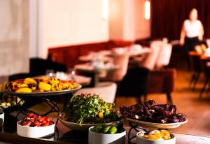 une table avec plusieurs assiettes de nourriture dans l'établissement Dave Downtown, a member of Brown Hotels, à Tel Aviv