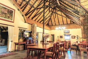 a dining room with a wooden table and chairs at Shikwari Suites - Shikwari Nature Reserve in Hoedspruit