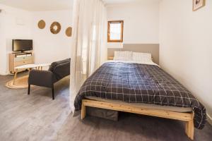 a bedroom with a bed and a chair and a television at Studio Hyères Médiéval in Hyères