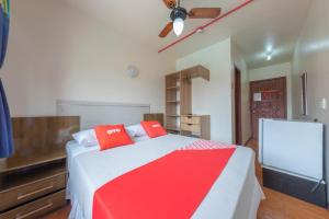 um quarto com uma cama com almofadas vermelhas em Pousada Japeju em Capão da Canoa