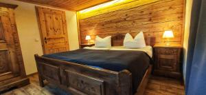 a bedroom with a bed with a wooden wall at Landhaus Speiser in Bolsterlang