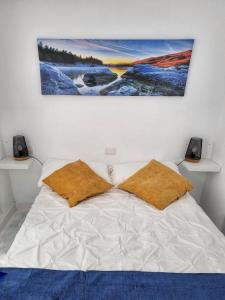 een wit bed met twee kussens erop bij Mar Bonanza in Orzola