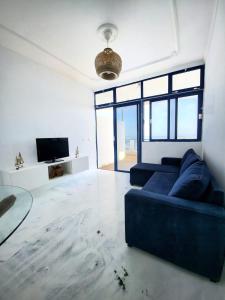 een woonkamer met een blauwe bank en een tv bij Mar Bonanza in Orzola