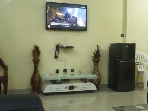 a living room with a flat screen tv on the wall at Résidence Lynda Prestige in Ouagadougou