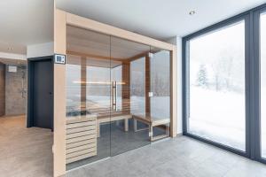 a glass room with a desk and a large window at Hideaway Dachstein West by ALPS RESORTS in Sankt Martin am Tennengebirge