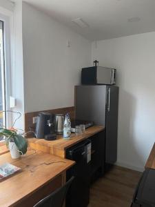 a kitchen with a black refrigerator and a wooden table at Propeller Gästehaus EG in Eppingen