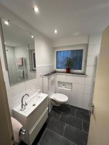 a bathroom with a sink and a toilet and a mirror at Großzügiges Zimmer mit Terrasse am Rheinsteig in Linz am Rhein