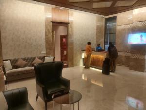a lobby with a waiting room with a chair and a tv at Adiva Residency Beacon, Grant Road, Mumbai in Mumbai