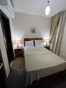 een slaapkamer met een groot bed en 2 lampen op tafels bij Appartment - Porto Sharm El Sheikh - Chalet 61205 B in Sharm El Sheikh