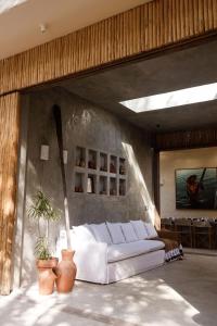 ein Wohnzimmer mit einer weißen Couch in einem Zimmer in der Unterkunft Pousada Zinga Caraíva in Caraíva