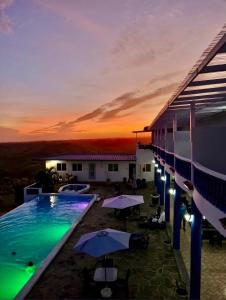a resort with a pool and umbrellas at sunset at Hotel Eclipse, Playa Coronado in Playa Coronado