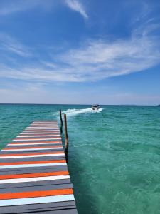 a dock in the ocean with a boat in the water at S Beach Resort in Ko Kood