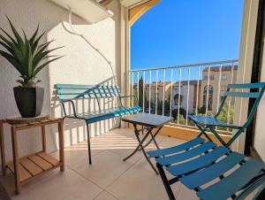 d'un balcon avec deux chaises, une table et une fenêtre. dans l'établissement Appartement avec WIFI et CLIMATISATION, proche golf et île des loisirs, au Cap d'Agde