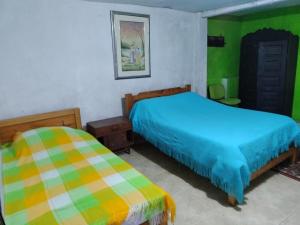 a bedroom with two beds and green and colorful walls at Atardecer De Salento in Salento