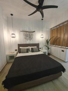 Schlafzimmer mit einem großen Bett und einem Deckenventilator in der Unterkunft Costa Bianco Luxury Home in Agios Nikolaos