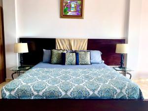 Schlafzimmer mit einem Bett mit einer blauen und weißen Bettdecke in der Unterkunft Hotel Eclipse, Playa Coronado in Playa Coronado