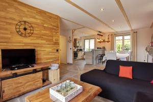 uma sala de estar com um sofá e uma televisão em Belle maison rénovée, 5mn à pied de la mer, classée meublé de tourisme 3 étoiles em Île-Tudy