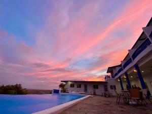 um pôr-do-sol sobre uma piscina num resort em Hotel Eclipse, Playa Coronado em Playa Coronado