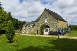 una grande casa in pietra con un cortile verde di Manoir de Saint-Fiacre a Malansac