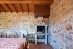 een keuken met een fornuis in een stenen muur bij Casas Lar de Arousa I y II in Catoira