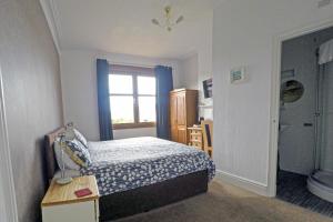 een kleine slaapkamer met een bed en een raam bij Ashdale Guest House in Llandudno