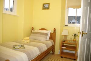 Un dormitorio con una cama y una mesa con un libro. en Adam Place Guest House, en Windermere