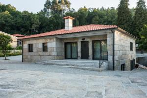 a small stone house with a red roof at Casa do Vale in Fafe
