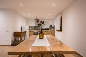 a kitchen with a wooden table with a vase of flowers at Casa do Vale in Fafe +35 photos