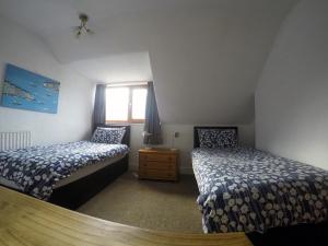 een slaapkamer met 2 bedden en een raam bij Ashdale Guest House in Llandudno