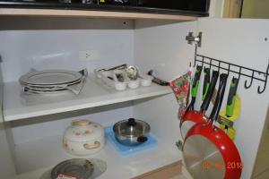 a kitchen counter with utensils on a shelf at SMDC Wind Residences 102 Loft Bedroom Facing Amenities with WIFI and Parking in Tagaytay
