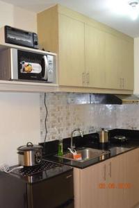 uma cozinha com um lavatório e um micro-ondas em SMDC Wind Residences 102 Loft Bedroom Facing Amenities with WIFI and Parking em Tagaytay