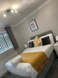 una camera da letto con letto, cuscini e finestra di Peaceful 3 Bed Home a Basildon