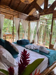 a large bed in a room with windows at Sikeo Eco Glamping in Icononzo