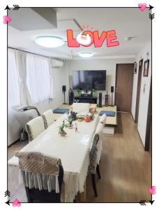 a living room with a large table with a love sign on the ceiling at kaneshiro guest house in Tokyo