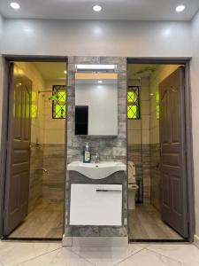 een badkamer met een wastafel, een douche en een spiegel bij Classy 3 bedroom apartment in Mombasa. in Mombasa