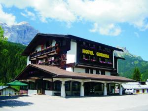 a hotel with a sign on the side of it at Hotel Corona in Val di Zoldo