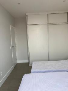 um quarto branco com 2 camas e um closet em Apartamento reformado, tudo novo, Copa-Ipanema no Rio de Janeiro
