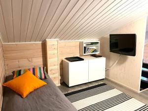 a small room with a bed and a tv at Vuosselin Kuura (2 mh + tilava parvi) in Kuusamo