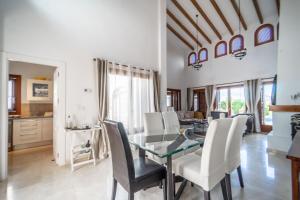 een eetkamer met een glazen tafel en witte stoelen bij Stunning detached Villa in El Valle Golf Resort - ZO24EV in Murcia