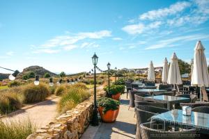 een restaurant met tafels en witte parasols bij Stunning detached Villa in El Valle Golf Resort - ZO24EV in Murcia