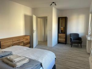 HiddenhausenにあるGemütliche 3Zi Ferienwohnungのベッドルーム1室(ベッド1台、椅子付)