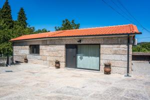 un pequeño edificio de ladrillo con techo naranja en Casa do Vale en Fafe