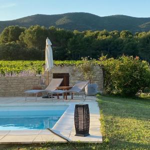 - une piscine avec des chaises, un parasol et une table dans l'établissement Mas Bastide st Victor pour 10 personnes, à Puyvert