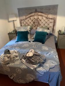 a bed with a blue and white blanket and pillows at Tivoli en Provence in Cotignac