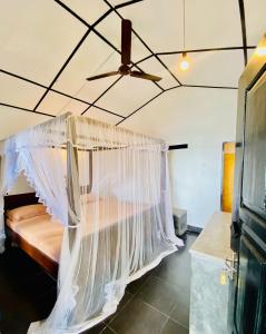 a bedroom with a bed with a mosquito net at Praneeth Guest House in Mirissa